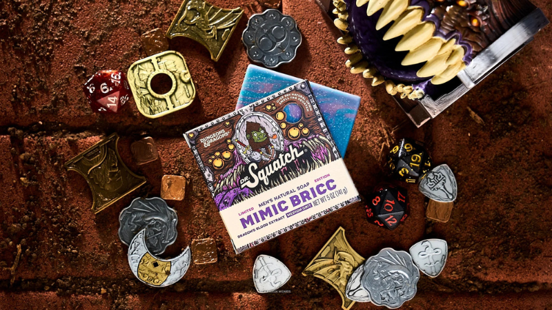 A bar of Dr. Squatch "Mimic Bricc" soap featuring the D&D license, set against a table filled with gold coins and a mini mimic treasure chest.